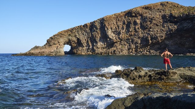 Arco dell'Elefante, rock gate, man standing on rock, Pantelleria, Pelagic Islands, Sicily, Italy