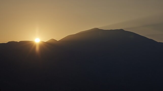 Sunrise, sun solidifies behind the double peak of Psiloritis, Meronas, Central Crete, Rethimnon Province, Crete, Greece