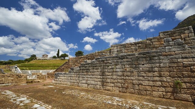 Historic remains of ancient walls against a cloudy sky and green landscape, Ancient city wall, Archaeological site, Ancient Messene, Capital of Messinia, Messini, Peloponnese, Greece