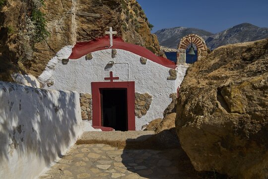 Legend, Crab, Mussel fisherman, Quiet chapel with red and white facade embedded in rocky landscape under blue sky, Chapel, Little church, Monastery Agia Kavouradena, Xirokambos, Leros, Dodecanese, Greek Islands, Greece