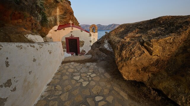 Legend, crab, shell fisherman, stone path to the chapel on the coast, surrounded by rocks, with calming sea view in the evening light, chapel, little church, Agia Kavouradena monastery, Xirokambos, Leros, Dodecanese, Greek Islands, Greece