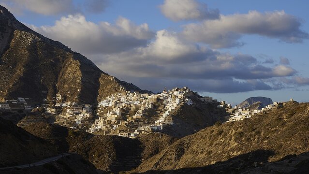 A picturesque village in the mountains, illuminated by sunbeams, surrounded by dramatic clouds, Colourful mountain village, Morning light, Olymbos, Karpathos, Dodecanese, Greek Islands, Greece