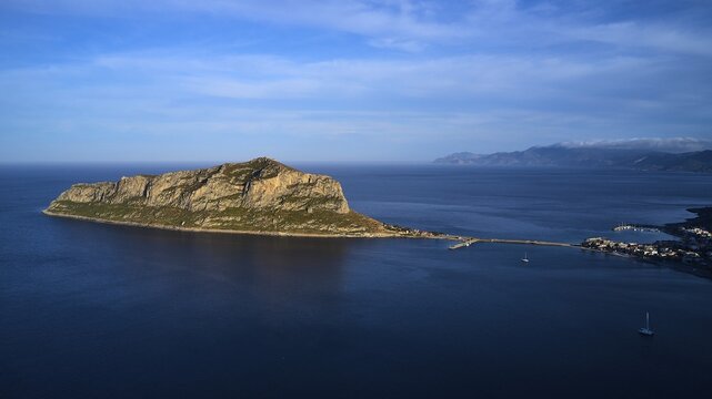 Drone shot, island in the sea, connected by bridge, mountains and sky in the background, Monemvasia, Monemvassia, Malvasy, small Byzantine town, rocky island, fortress, Laconia, Peloponnese, peninsula, Greece