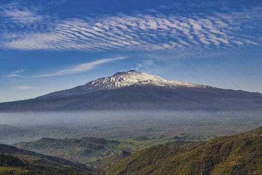 Etna in spring, panoramic view of a volcano with snow-capped peaks under wavy clouds, UNESCO World Heritage Site Etna, volcano, volcanism, Sicily, Italy