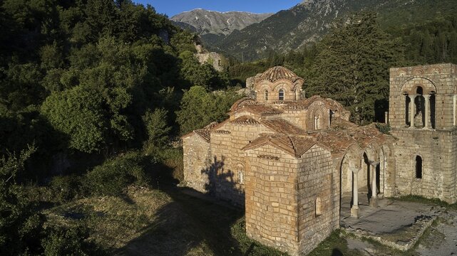 Drone shot, Church of Agia Sophia from the 14th century AD, An old church with ruins in the foreground and mountains in the background in sunshine, Mystras, Mistra, UNESCO World Heritage Site, Medieval Byzantine ruined city, northwest of Sparta, foothills of the Tyagetos Mountains, Peloponnese, peninsula, Greece