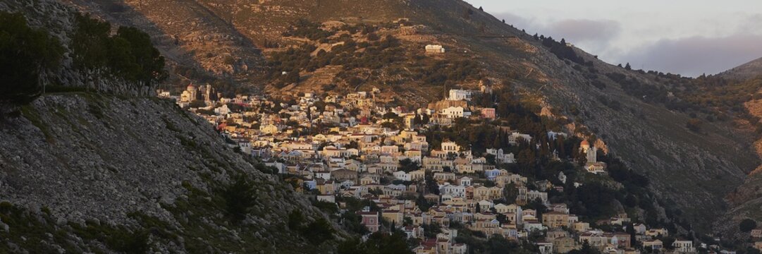 Town in the mountains in the warm morning light, Symi town, Symi, Dodecanese, Greek Islands, Greece