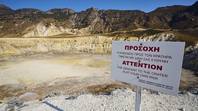 Warning sign in front of volcanic crater in sunny mountainous landscape, volcanism, volcanic island, Caldera Stefanos, Nisyros, Dodecanese, Greek Islands, Greece