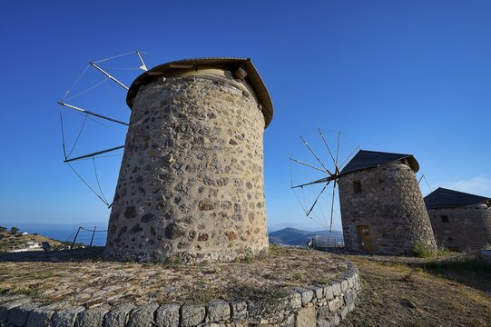 Two old stone windmills under a clear blue sky in a natural landscape, windmills, on a ridge, above Chora, main town of Patmos, Patmos, Old Town, Dodecanese, Greek Islands, Greece