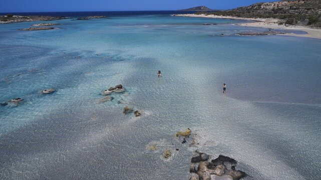 A quiet beach with clear water and stones, where isolated people enjoy the surroundings, Elafonissi, lagoon, south-west tip of Crete, Crete, Greek Islands, Greece