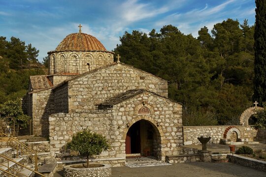 Historic stone church under a blue sky surrounded by trees, Thari Monastery, Moni Thari, near Gadouras Reservoir, lonely mountain region, Rhodes, Dodecanese, Greek Islands, Greece