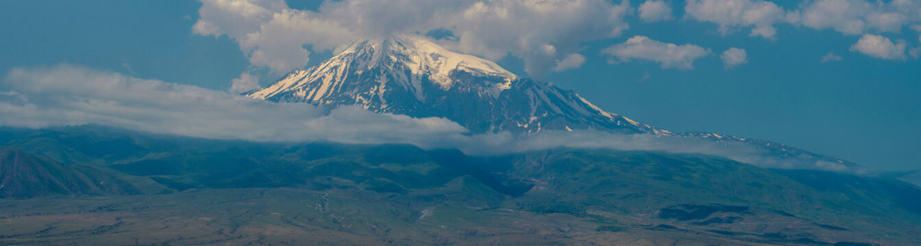 Majestic mount Ararat snow summit with green foothills and copy space sky