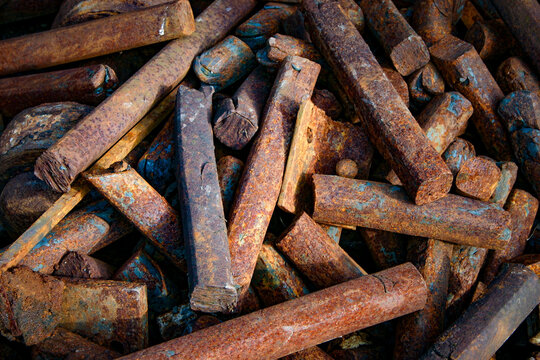 Rusted Metal Bars Heap. Short thick iron rods piled together at an old industrial furnace site showing heavy atmospheric corrosion.