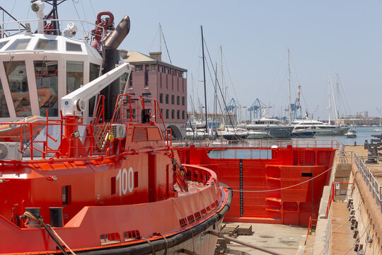 Red tugboat located out of the water in a dry dock in the port of Genoa