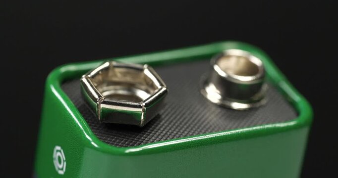 Nine-volt battery, or 9-volt battery - electric battery that supplies a nominal voltage of 9 volts. Green 9-volt battery ready to power devices