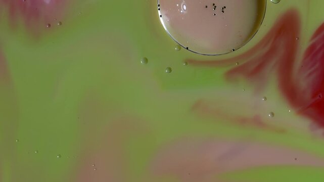 Abstract Fluid Art Macro - Swirling Lime Green and Red Paint with Glitter Bubble