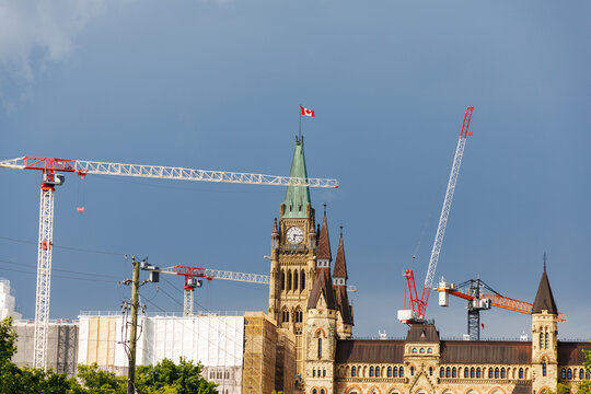 Parliament Hill restoration site with construction cranes in Ottawa. Historic Canadian parliament buildings renovation.