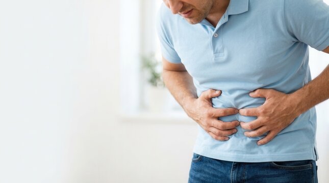 Close up of a man experiencing stomach ache and abdominal pain.