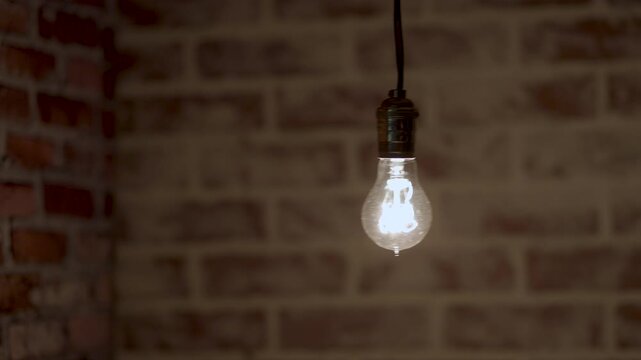 vintage scene of a light bulb swinging in front of an old brick wall