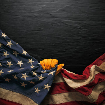 Worn work glove pulling back the American flag. Symbolic of blue collar workers, USA manufacturing, pride in products Made in United States of America, or to celebrate Father's day or US Labor Day.