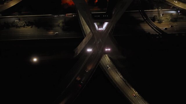 Night aerial overhead view of Octavio Frias de Oliveira bridge tower and cables with traffic in S&atilde;o Paulo, Brazil. Push in camera movement