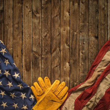 Work gloves with the American flag on wooden background. Symbolic of blue collar workers, USA manufacturing, pride in products Made in United States of America, or for Father's day or US Labor Day.