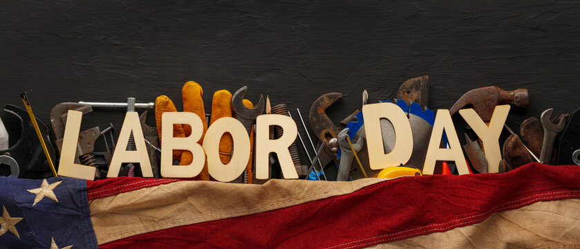 Labor Day greeting text with various work tools US American flag. Symbolic of blue collar workers, USA manufacturing, pride in products Made in United States of America, or celebrate US Labor Day.