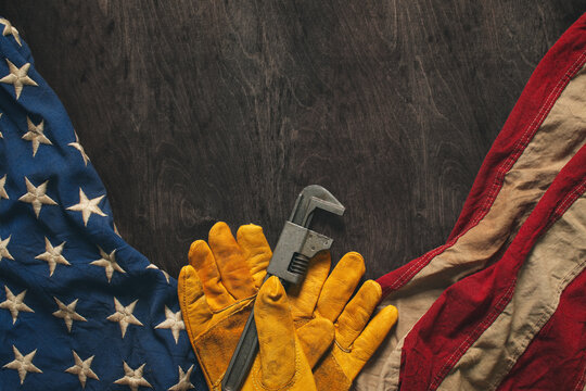 Work gloves with the American flag on wooden background. Symbolic of blue collar workers, USA manufacturing, pride in products Made in United States of America, or for Father's day or US Labor Day.