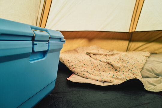 Blue cooler box and bedding inside a camping tent