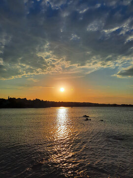 Wide shoot view of rocks, calm sea and colorful sky during sunset