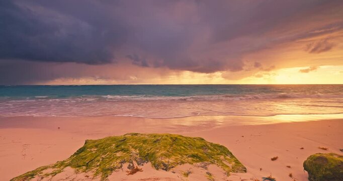 Scenic sunrise over beach with sea waves splashing on the sandy shore tropical vacation