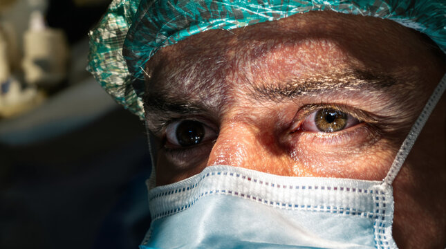 A doctor performing surgery, tired eyes.