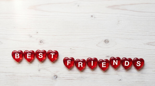 Red heart shaped letter beads spelling Best Friends on a rustic wooden background, with copy spce, clebrating love, appreciation, companionship, kindness, loyalty, trust and Friendship Day