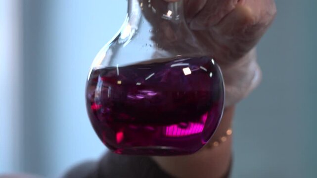 Close-up footage of a laboratory experiment with test tubes and glassware, featuring bubbling and mixing liquids. Scientific research process in a modern lab environment, showcasing chemical reactions