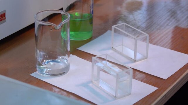 Close-up footage of a laboratory experiment with test tubes and glassware, featuring bubbling and mixing liquids. Scientific research process in a modern lab environment, showcasing chemical reactions