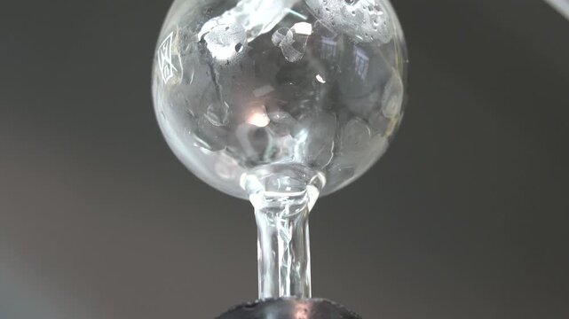 Close-up footage of a laboratory experiment with test tubes and glassware, featuring bubbling and mixing liquids. Scientific research process in a modern lab environment, showcasing chemical reactions