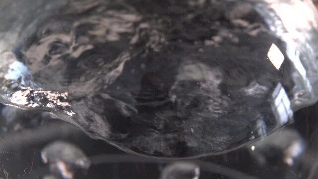 Close-up footage of a laboratory experiment with test tubes and glassware, featuring bubbling and mixing liquids. Scientific research process in a modern lab environment, showcasing chemical reactions