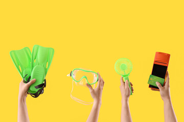 Hands holding snorkeling gear, handheld fan, and payment terminal with card © Pixel-Shot