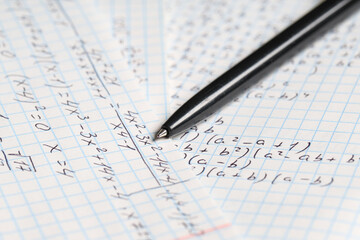 Obraz premium Copybook with handwritten maths formulas and pen as background, closeup