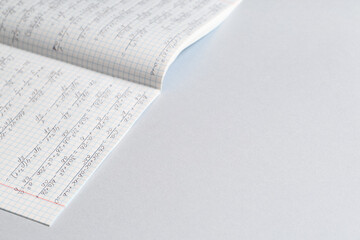 Obraz premium Copybook with handwritten maths formulas on grey background