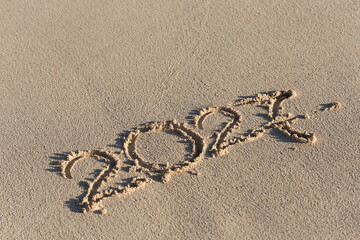Fototapeta premium Inscription 2027 on sandy beach. Celebration of new year