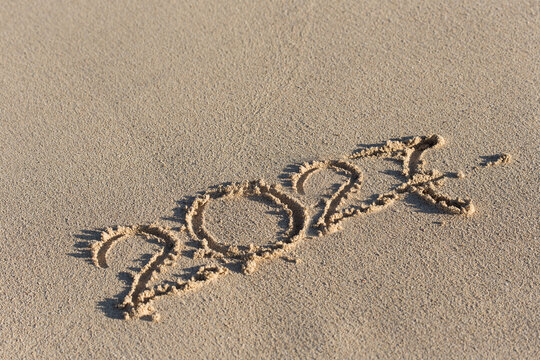 Inscription 2027 on sandy beach. Celebration of new year