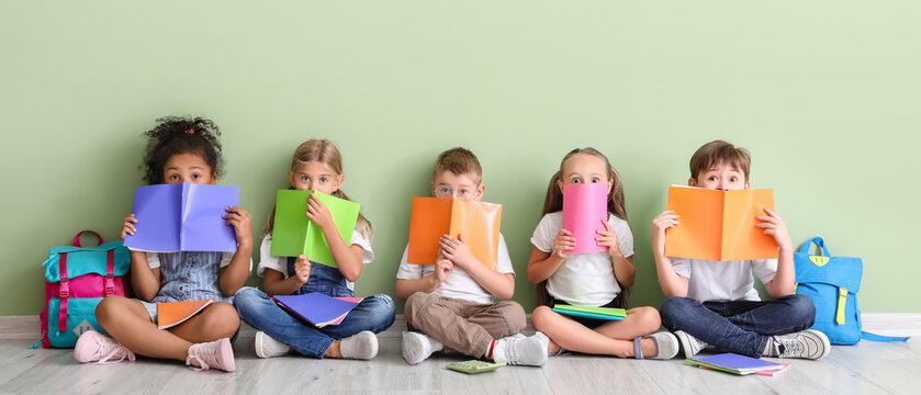 Group of diverse children sitting with colorful notebooks