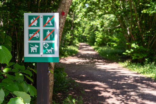 Forest hiking trail rules sign at Baltic Sea coastal path entrance