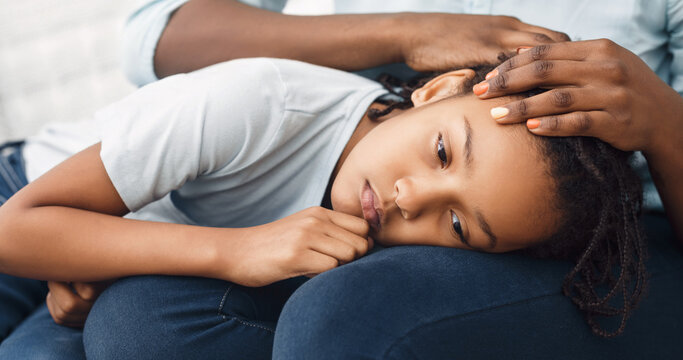 Close-up Of Girl's Head On Lap, African Mother Comforting Her Sad Child On Sofa At Home, Panorama
