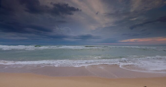 Stormy Beach at Sunrise With Dramatic Sky, Rolling Waves on Empty Sandy Shore 