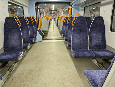Empty train carriage interior with all seats free and lots of space.