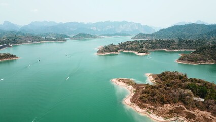 Obraz premium Khao sok lake aerial view showing limestone islands and boats in emerald water