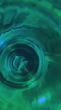 Vertical video with transparency in blue-green tones. Abstract moving light flashes. Perfect format for social media posts and modern advertising visuals.Space for text.