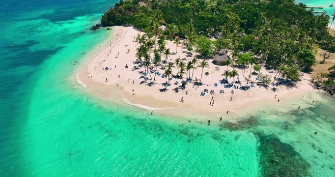 Aerial View Of Tropical Island Beach With Palm Trees, Turquoise Ocean Water People and Resort Sunbeds Paradise summer Vacation Bacardi Dominican republic