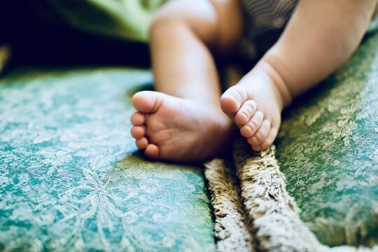 Close-up of Baby boy's bare Feet sitting on a sofa